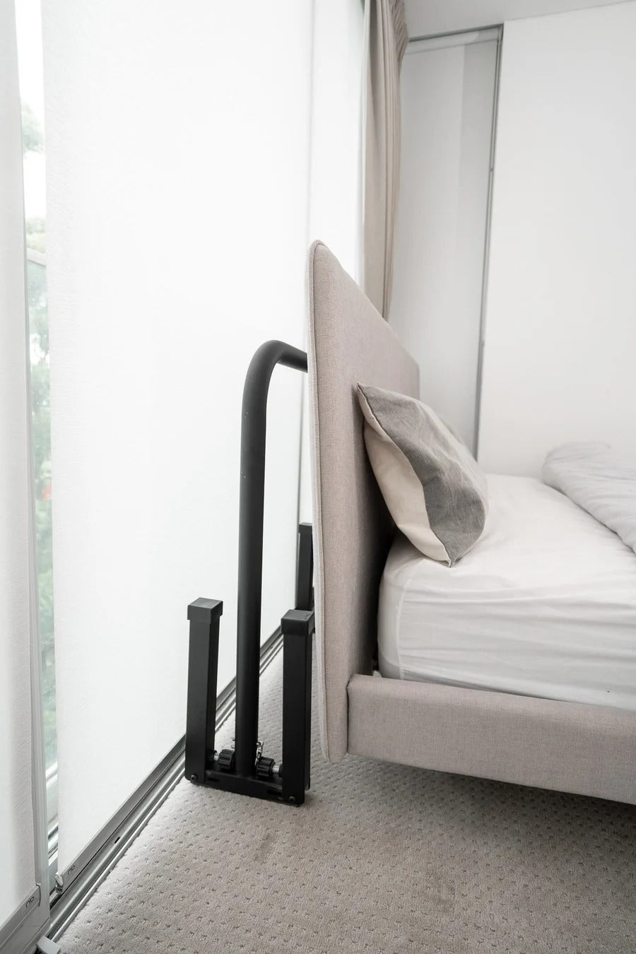 Compact dip bars stored beside a bed